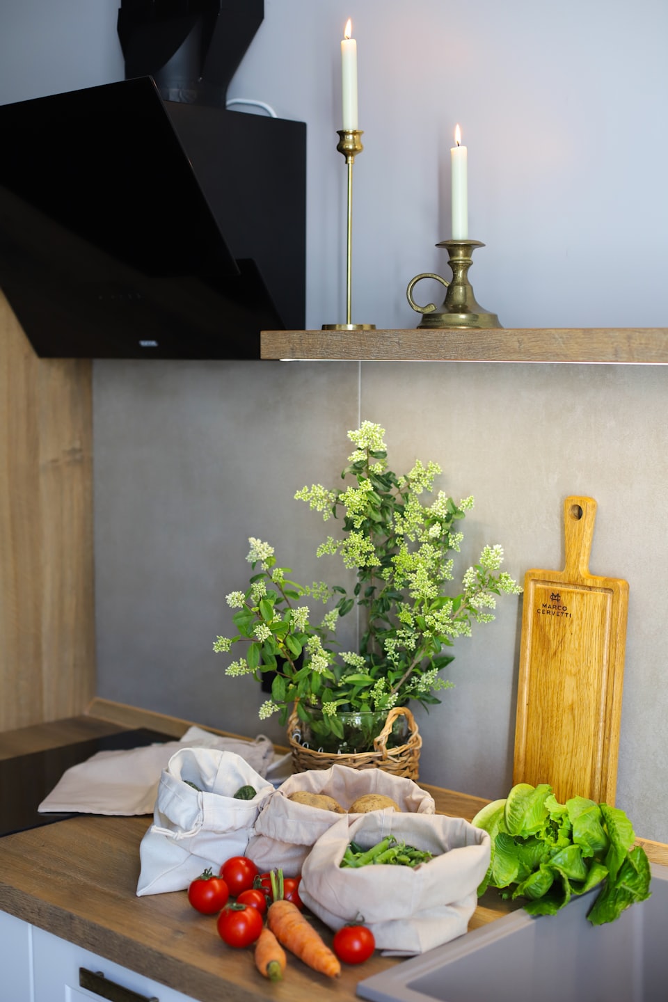 Verdure fresche disposte su un bancone da cucina in legno pulito.